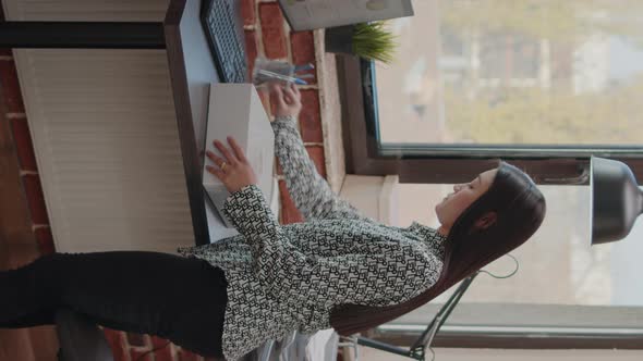 Vertical Video Woman Packing Up Belongings in Box After Getting Fired alt