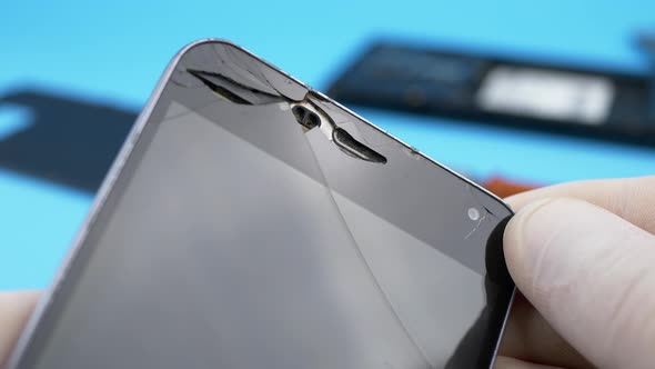 Technician Looking for Broken Screen on Smartphone alt