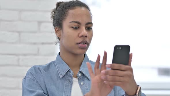 Young African Woman Using Smartphone Messaging alt