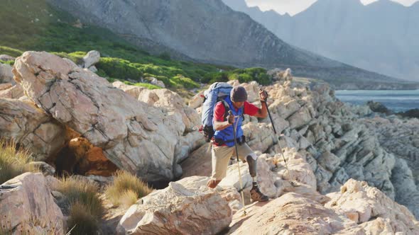 Sporty mixed race man with prosthetic leg hiking alt