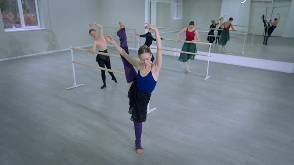 Wide Shot Flexible Slim Young Ballerina Putting Leg Down Looking at Camera Smiling alt