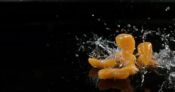 Clementines, citrus reticulata, Fruits falling on Water against black Background, Slow Motion 4K alt
