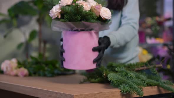 Blurred Unrecognizable Florist Stretching Bouquet with Green Branches and Pink Flowers Putting alt