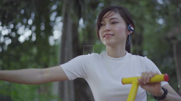 woman exercise on elliptical walk trainer fitness machine in park alt