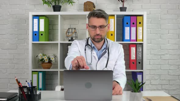 Remote doctor wears white medical coat in hospital office opens using laptop alt
