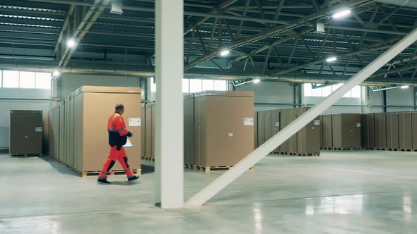 Warehouse Worker Is Walking Along the Refrigeration Factory alt
