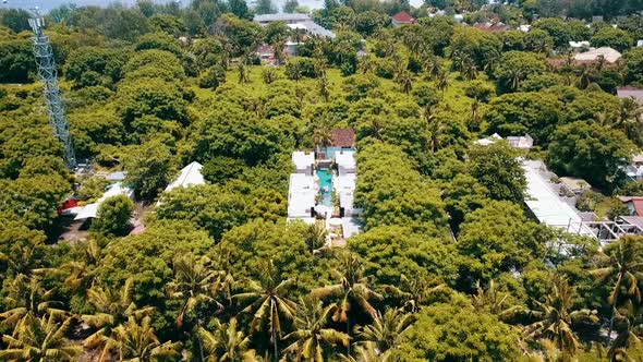 Buttery soft aerial flight fly backwards drone shot of a luxury resort hotel with pool on a scenic t alt