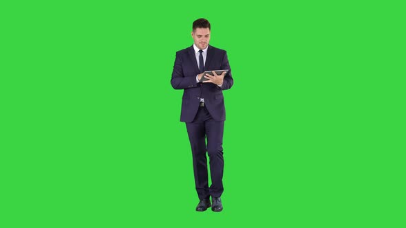 Businessman swiping pages on a tablet and talking to camera alt