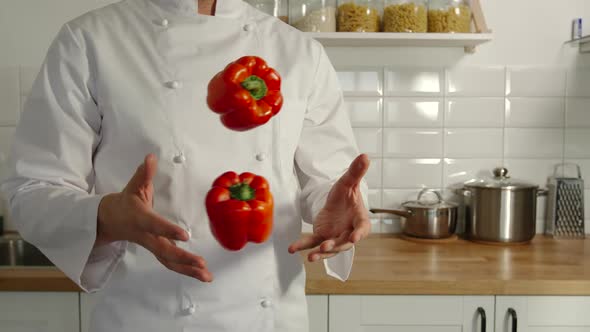 Chief-Cooker Juggles A Red Pepper Bells In A Kitchen