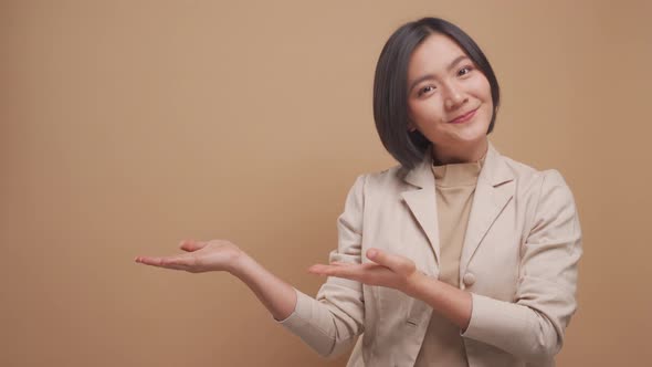 Confident asian business woman happy standing and pointing to copy space isolated