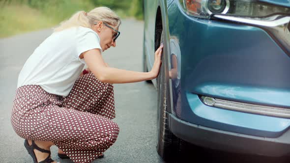 Woman Check Car Tire Pressure. Vehicle Trouble On Road On Vacation Trip. Female Trying Fix Car Tire. alt