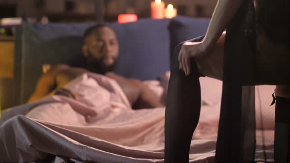Sexy Woman Putting Stocking in Front of Man