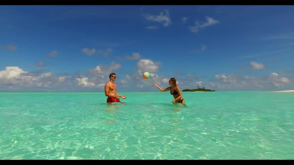 Guy and girl posing on beautiful coast beach holiday by blue green lagoon and white sand background  alt