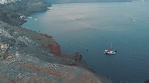 Fly over the amazing cliff in Oia, village in Santorini, Greece at sunset