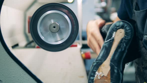 Bottom Part of a Shoe Is Getting Polished By a Factory Worker alt