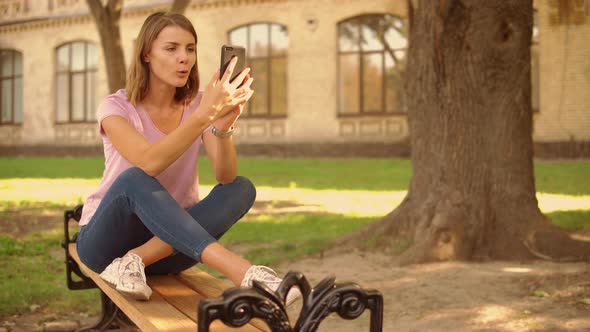Young Woman Has Video Call Near College alt
