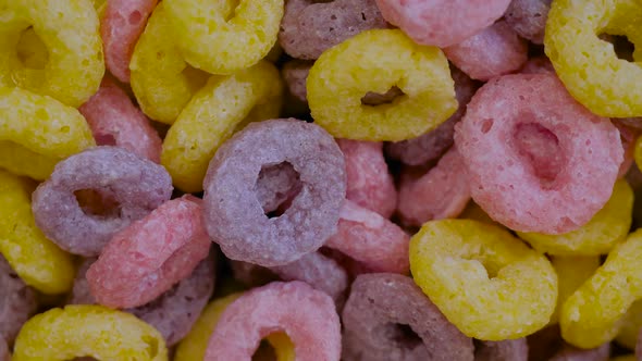 Heap of Colorful Cereal Loop Rings on Rotating Surface  Close Up