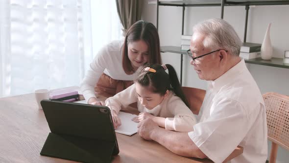 Family gathered to help a girl during distance learning. Distance learning concept. alt