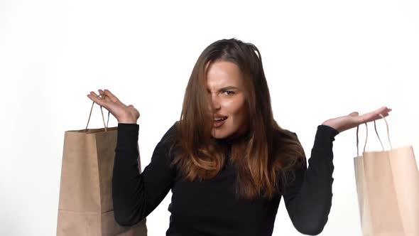 Positive human emotions. Pretty young woman with shopping bags after successful shopping alt
