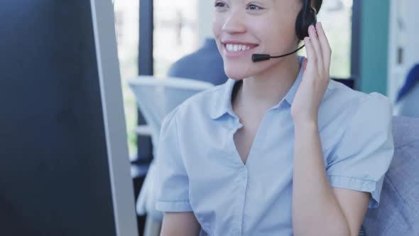 Young woman with headset working on computer alt