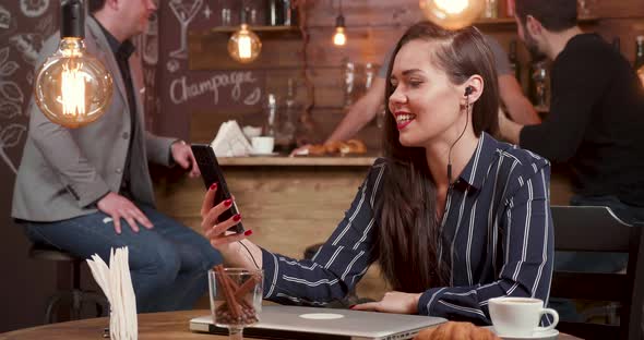 Beautiful Female Freelancer Having a Video Chat in a Coffee Shop alt
