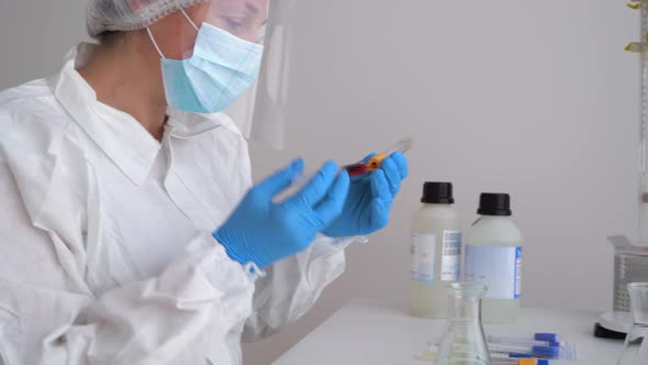 Doctor wearing protective clothing, doing blood test