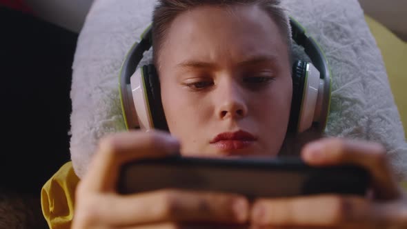 Teenager Playing Game on Smartphone alt