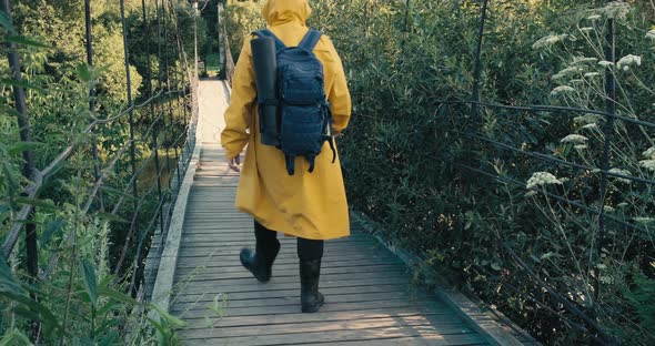 Man with Backpack in Raincoat is Engaged in Hiking