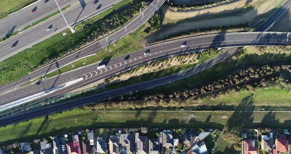 Smooth tracking aerial perspective shot from top down of vehicles entering the main carriage way of alt