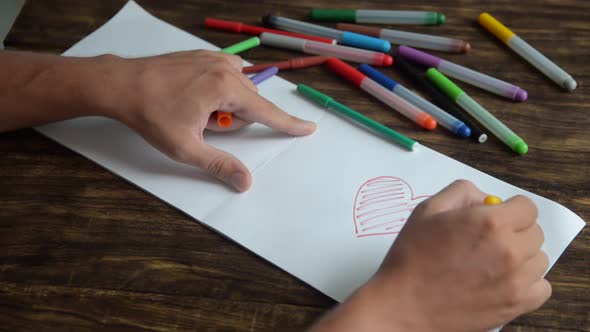 Close Up of Hand Coloring of Heart Sea Sun alt