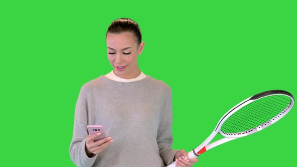 Pretty Young Female Tennis Player Walking and Using Smart Phone on a Green Screen Chroma Key