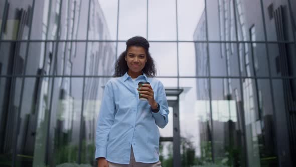 Satisfied Finance Manager Smiling Holding Hot Coffee Cup in Empty Business Yard alt
