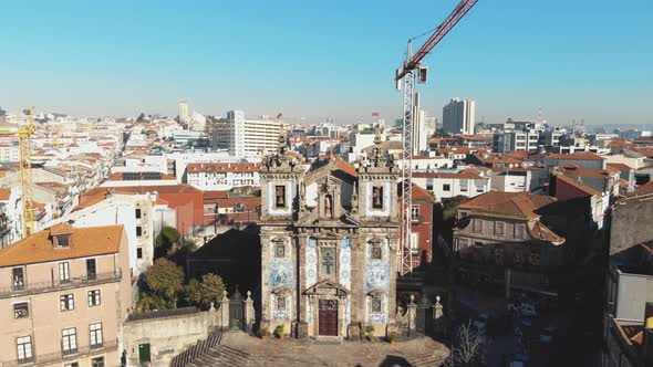 Church of Saint Ildefonso near Batalha Square in Oporto, Portugal - Pull back ascend aerial shot alt
