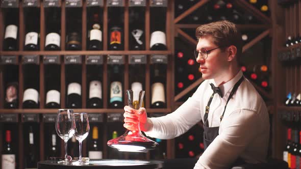 Wine Taster or Degustator Pouring Red Wine Into Carafe To Make Perfect Color alt