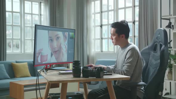 Asian Cameraman Using Desktop Computer For Editing Photos While Working At Home alt