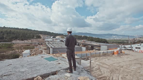 Man flying a drone for construction survey in a large highway construction site alt