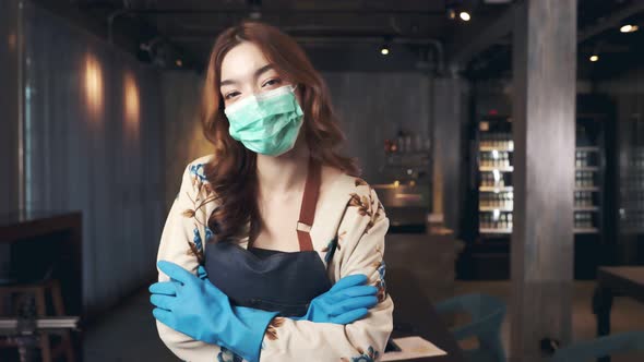 Business owner attractive young mixed race woman in apron hanging we're open sign alt