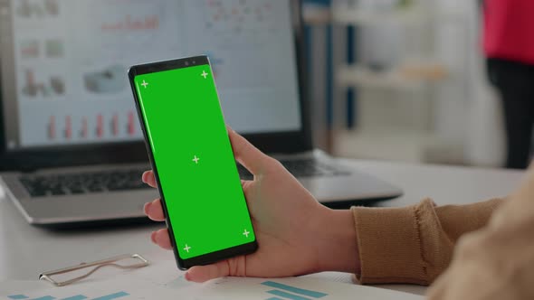 Close Up of Woman Holding Isolated Green Screen Vertically on Phone alt