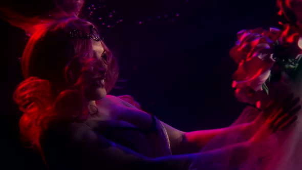 a Woman with Long Red Hair, Wearing a Tiara and a Corset, Floats in the Dark Under the Water. She alt