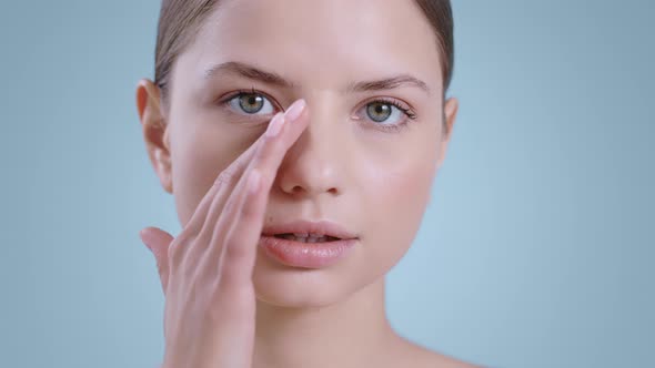 Close Up of Attractive Woman Touching Face with One Hand While Looking to Camera  alt