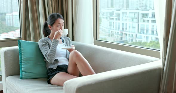 Woman watching the view out of window at home  alt
