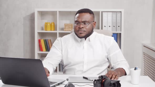 Workplace of freelance worker at home office. Young African-American man. alt