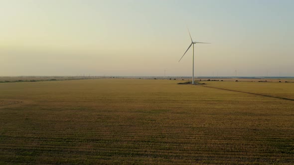 Aerial View of a Windmill in Rural Fields on a Beautiful Summer Evening alt