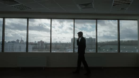 Contour Lighting Businessman Walks in Front of a Panoramic Window Waiting Process Morning in a alt