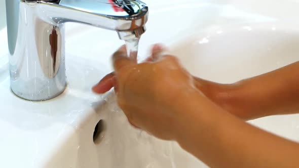 The child washes his hands with soap under the sweat of water. Clean hand concept idea. alt