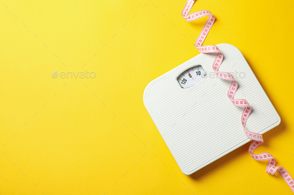Scales and measuring tape on yellow background. Weight loss concept Stock  Photo by AtlasComposer