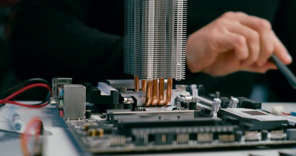 Technician Man Fixes PC By Changing Thermal Paste on CPU Processor in Computer