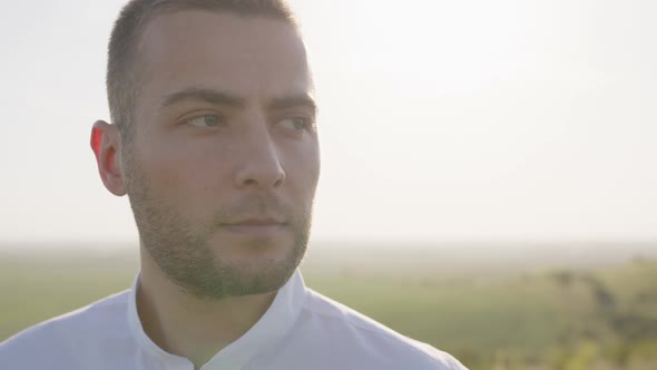 Close Up View of Groom's Face in Blue Background alt