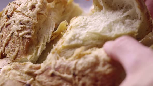 Close Up on Hands Tearing Piece of Fresh Baked Steamy Bread alt