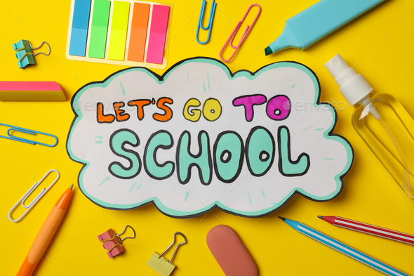 Text Let\'s go to school and school supplies on yellow background